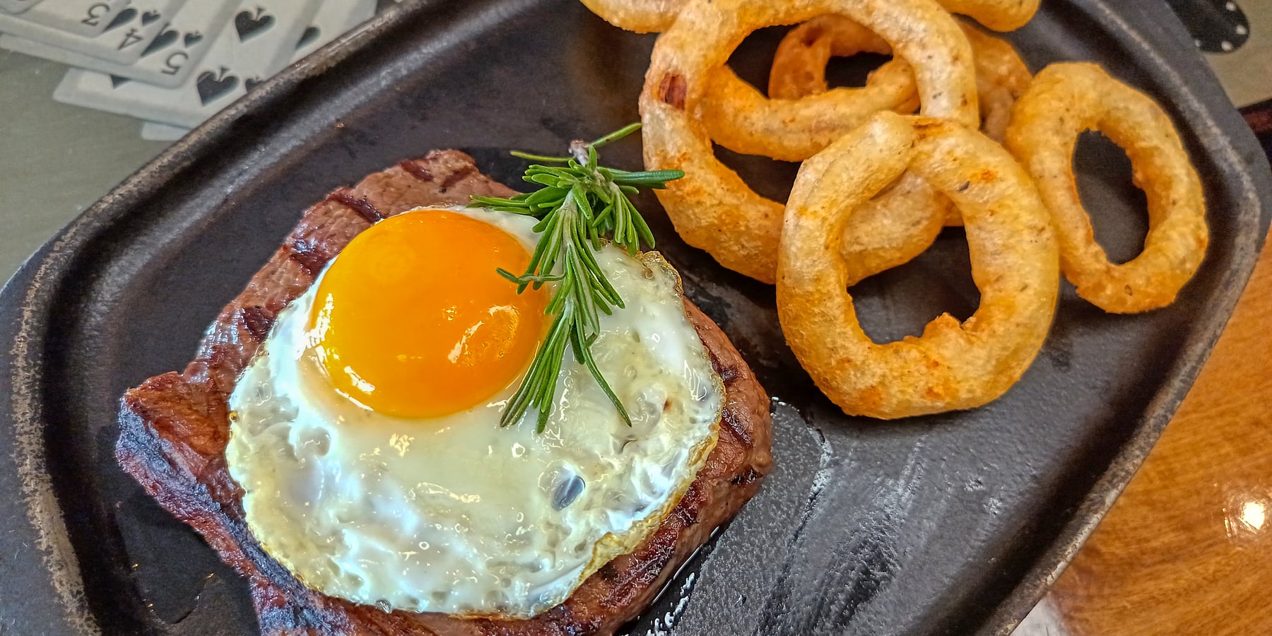 Sizzling Prime Steak topped with Fried Egg and Onion Rings